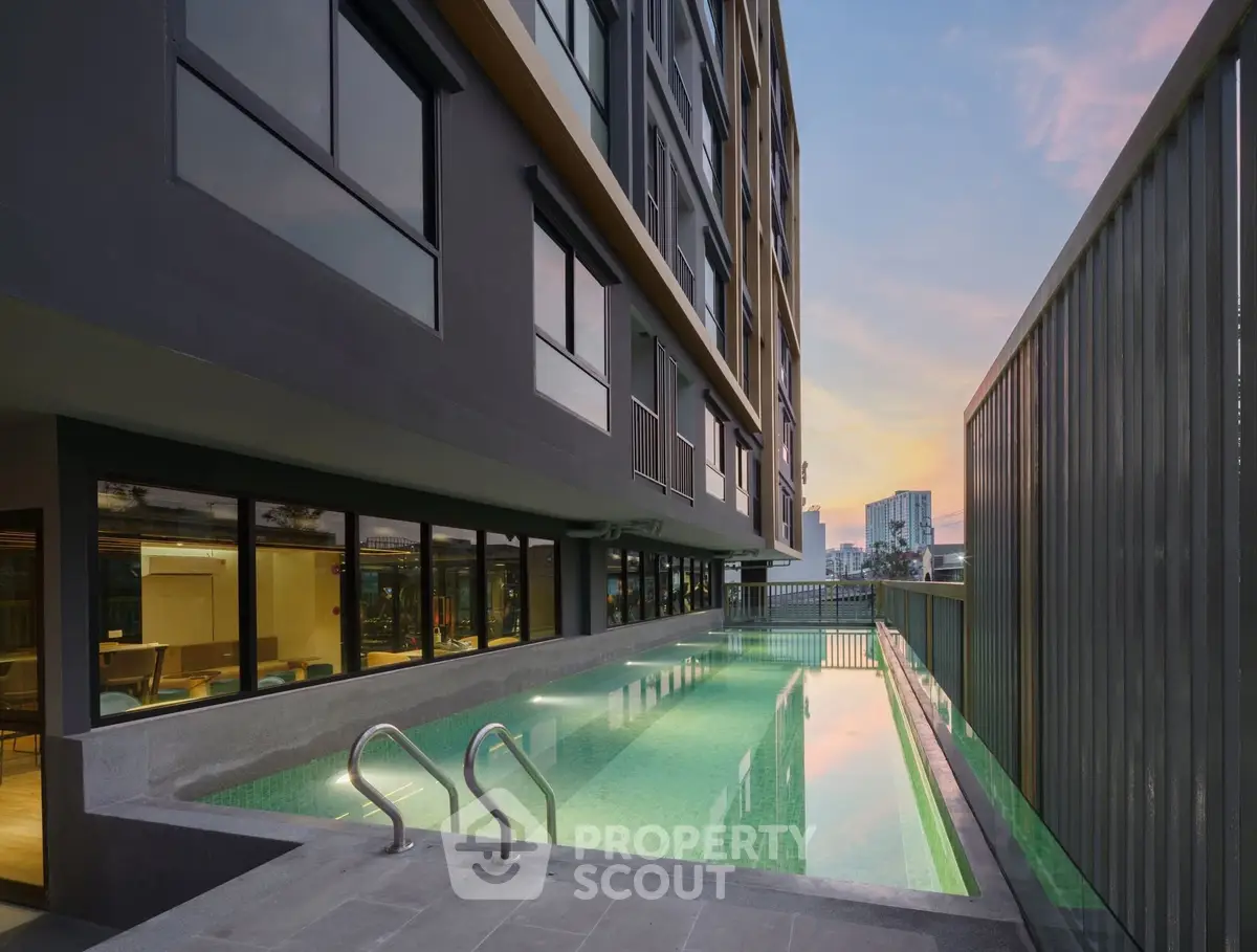 Modern apartment building with sleek pool and sunset view, perfect for luxury urban living.