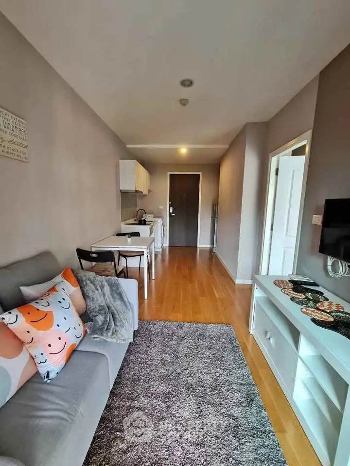 Modern living room with cozy decor and open kitchen layout in a stylish apartment.
