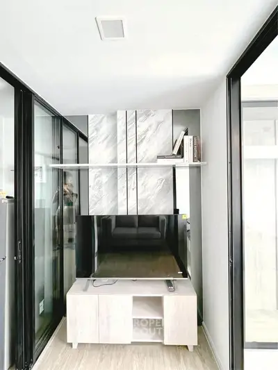 Modern living room with sleek TV unit and glass sliding doors