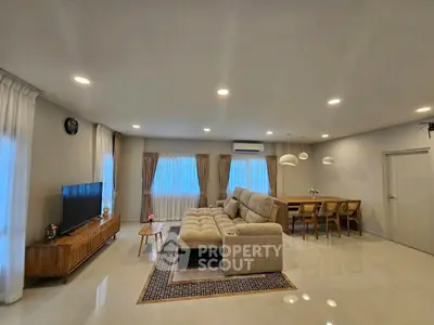 Spacious modern living room with elegant dining area and cozy seating, perfect for family gatherings.