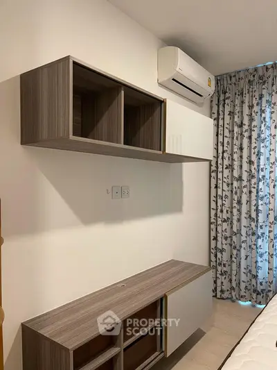 Modern bedroom with sleek wooden storage and air conditioning unit