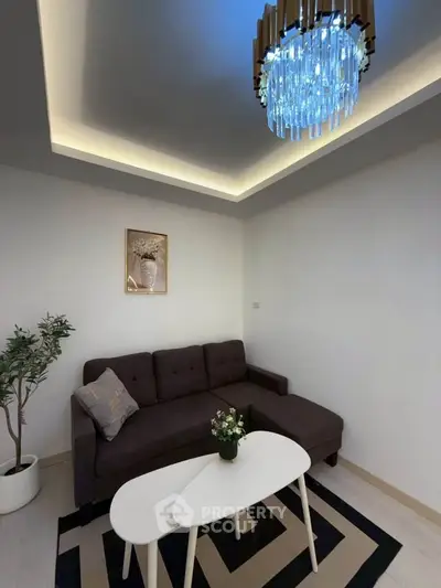 Modern living room with stylish chandelier and cozy sofa