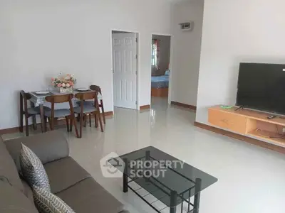 Spacious living room with modern furniture and TV, perfect for family gatherings.