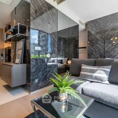 Modern living room with sleek marble walls and cozy gray sofa, featuring a stylish indoor plant.