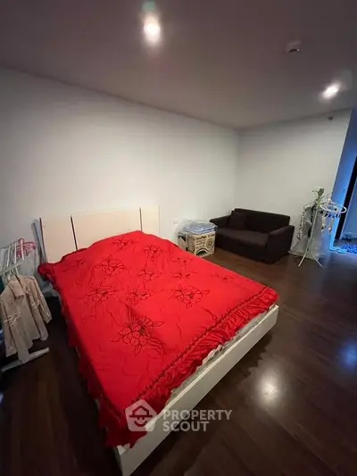 Spacious bedroom with modern decor and cozy seating area, perfect for relaxation.