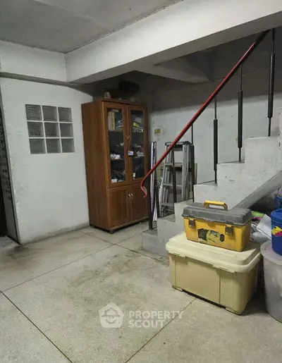 Spacious storage area under staircase with cabinet and toolboxes, ideal for organizing household items.