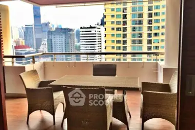 Spacious balcony with city view and outdoor dining set in urban high-rise.