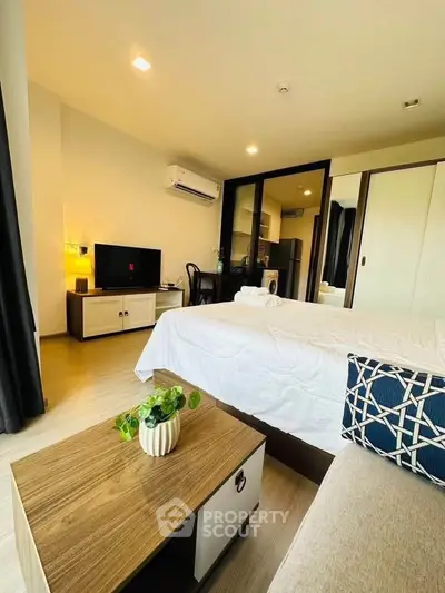 Modern bedroom with stylish decor, featuring a cozy bed, TV, and air conditioning in a bright, inviting space.