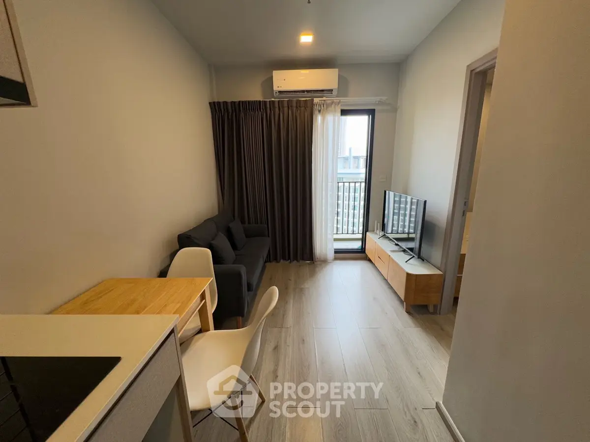 Modern living room with balcony access and sleek furniture in a cozy apartment.