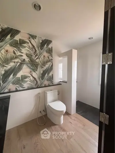 Modern bathroom with tropical accent wall and sleek fixtures
