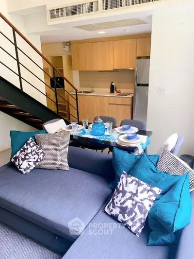 Stylish duplex living room with modern kitchen and cozy seating area