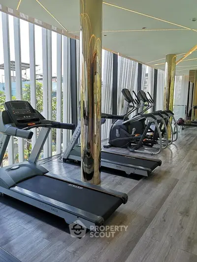 Luxurious gym with modern treadmills and floor-to-ceiling windows in a high-end residential building.
