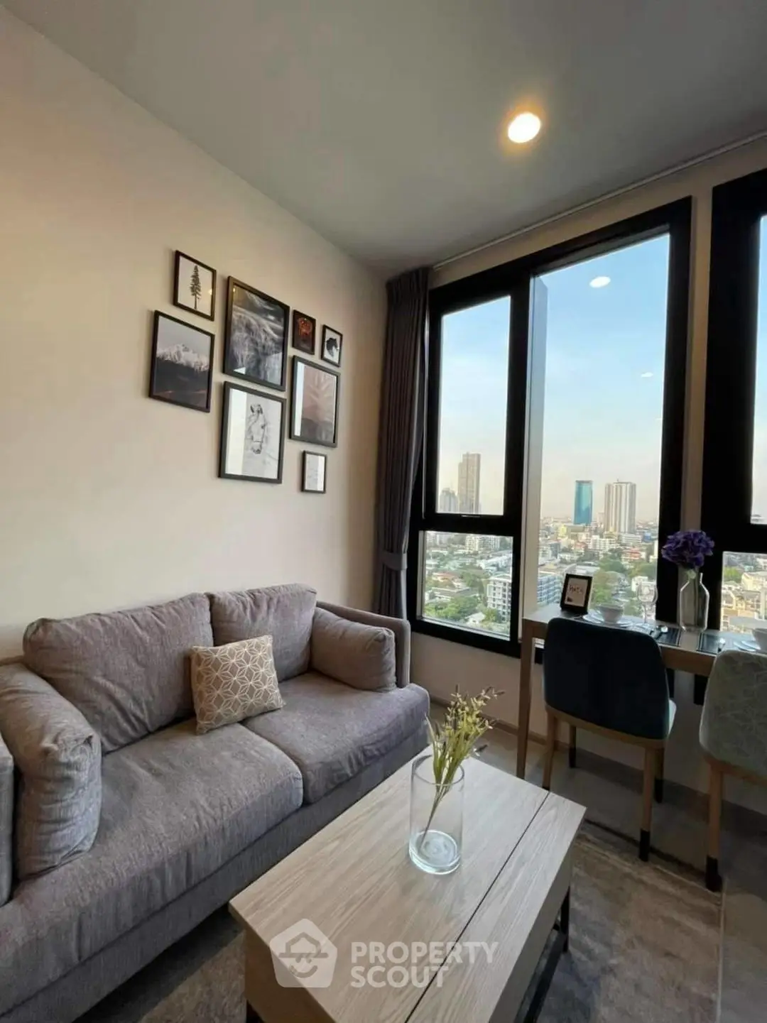 Chic living room with city view, cozy sofa, and stylish decor in modern apartment.