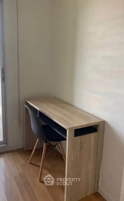 Minimalist study nook with wooden desk and modern chair in bright room.