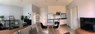 Modern open-plan living room with stylish kitchen and cozy seating area.