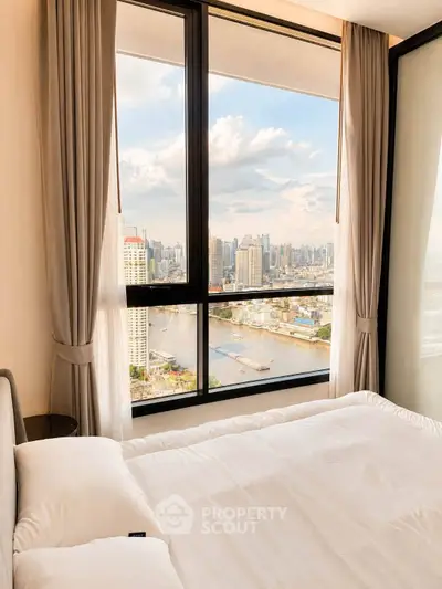 Luxurious bedroom with stunning city view through large windows, featuring elegant curtains and plush bedding.