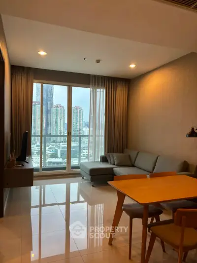 Modern living room with city view, featuring sleek furniture and large windows for natural light.