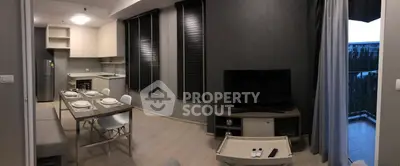 Modern open-plan living room with dining area and balcony view, featuring sleek furniture and contemporary design.