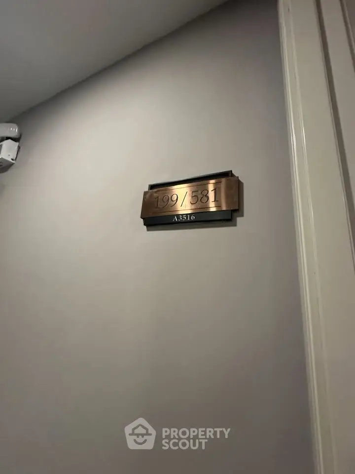 Modern apartment door with sleek number plaque in a well-lit hallway.
