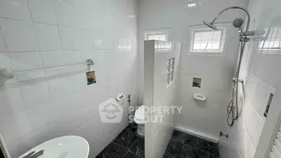 Modern bathroom with sleek white tiles and a walk-in shower