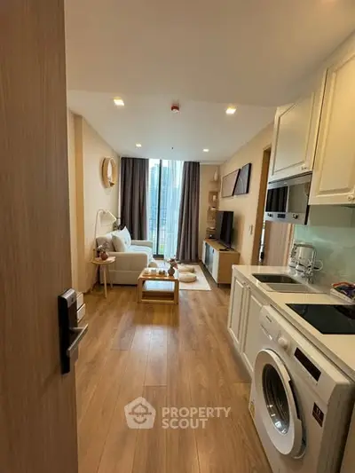 Modern open-plan living room with kitchen, featuring wooden floors and city view.