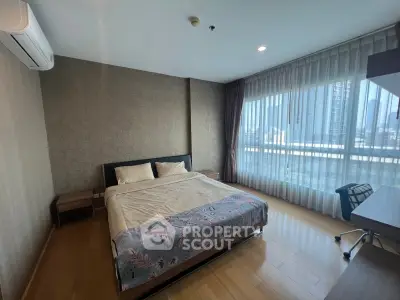 Spacious bedroom with large windows and city view in modern apartment