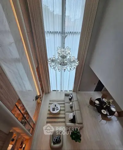 Luxurious high-ceiling living room with elegant chandelier and modern decor