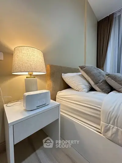 Cozy bedroom with modern nightstand and soft lighting, perfect for relaxation.
