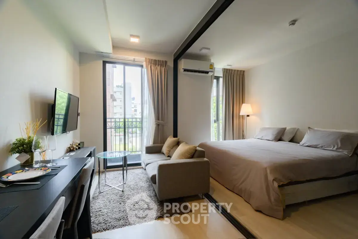 Modern studio apartment with cozy living area and large window view