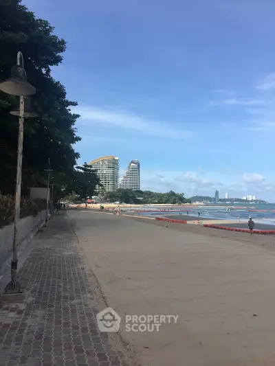 Stunning beachfront view with modern high-rise buildings under a clear blue sky.