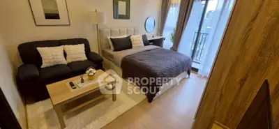 Cozy bedroom with modern decor and city view balcony, perfect for urban living.