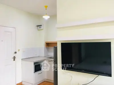 Modern compact kitchen with microwave and TV in cozy apartment