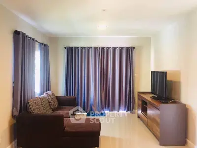 Cozy living room with modern sofa and entertainment unit, perfect for relaxation.