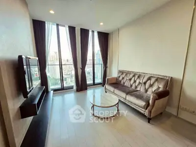 Modern living room with city view, featuring elegant sofa and wall-mounted TV, ideal for urban living.