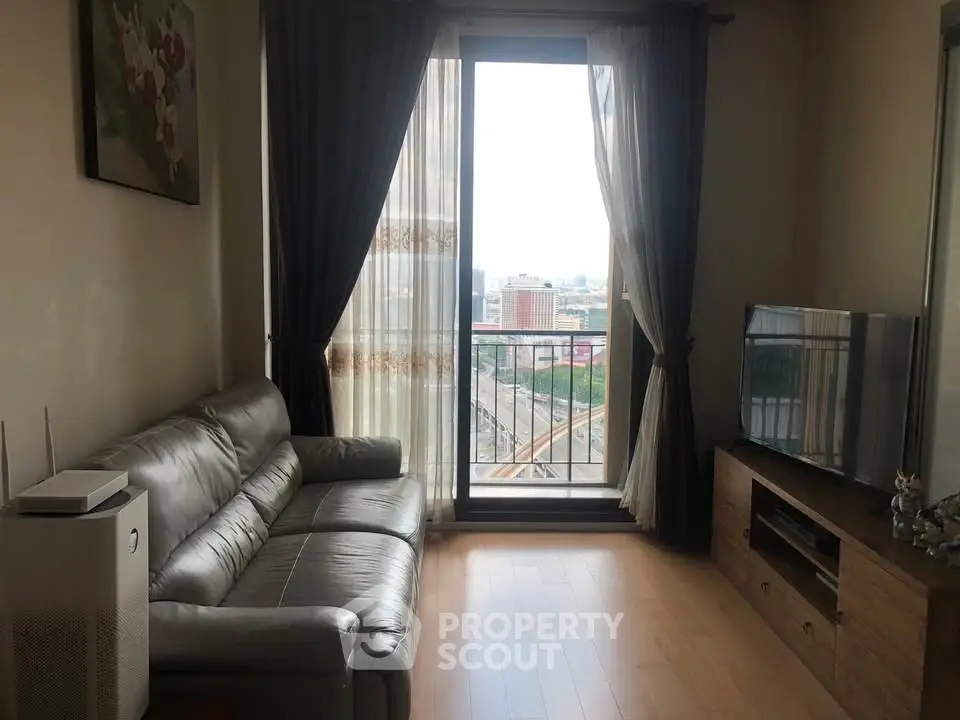 Modern living room with leather sofa and city view from balcony, perfect for urban living.