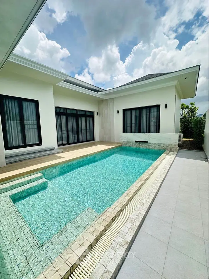 Luxurious modern villa with private swimming pool and elegant patio under a clear blue sky.