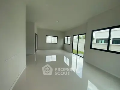 Spacious modern living room with large windows and glossy tiled floors