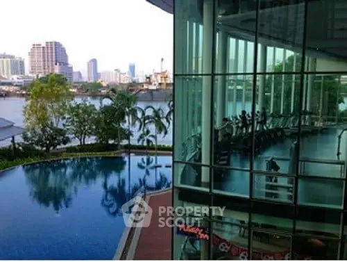 Luxurious urban condo with pool and gym overlooking city skyline and river view.
