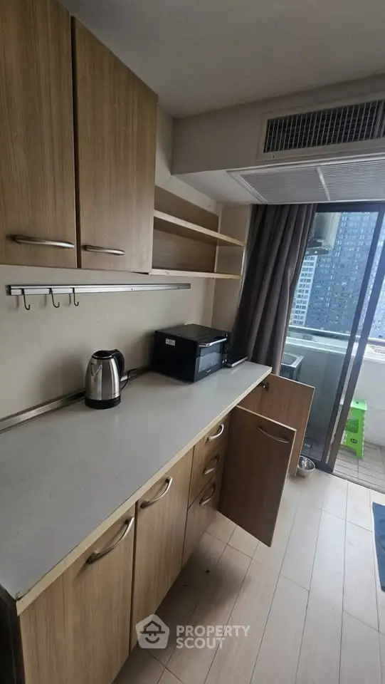 Modern kitchen with wooden cabinets and balcony view in urban apartment