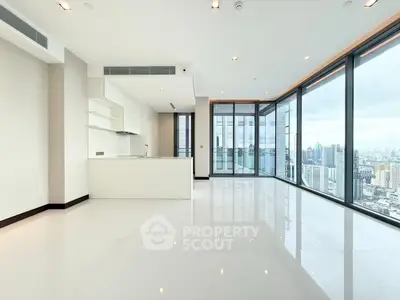 Spacious modern apartment with panoramic city views and sleek open kitchen.