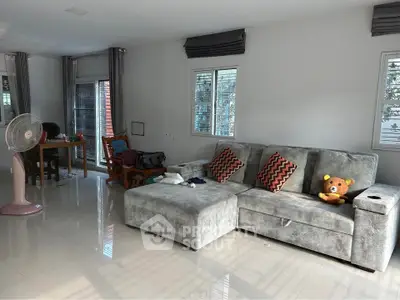 Spacious living room with modern gray sofa and natural light
