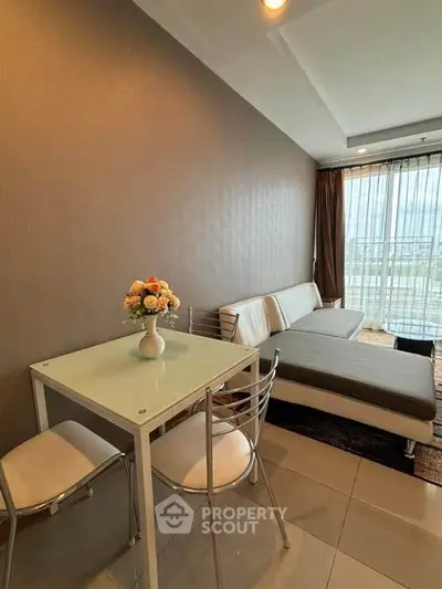 Modern living room with sleek furniture and large window offering city view.