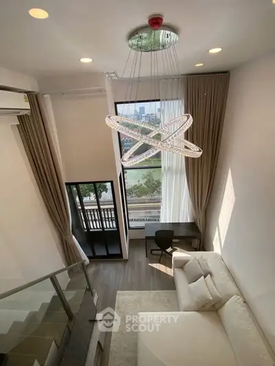 Luxurious modern living room with high ceiling and stunning city view, featuring elegant chandelier and cozy seating area.