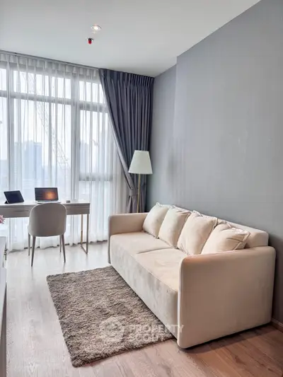 Modern living room with cozy sofa, elegant desk, and large window with natural light.