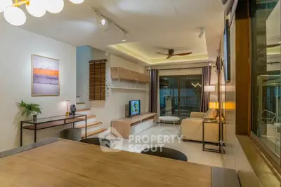 Modern living room with stylish decor and open layout, featuring a cozy seating area and elegant lighting.