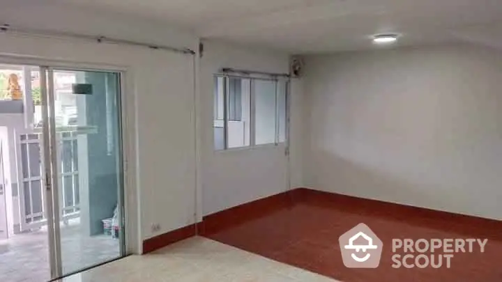 Spacious empty room with sliding glass doors and tiled floor