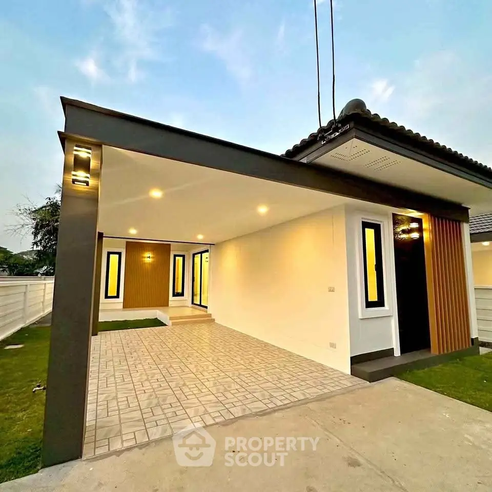 Modern single-story house with stylish exterior lighting and spacious driveway.