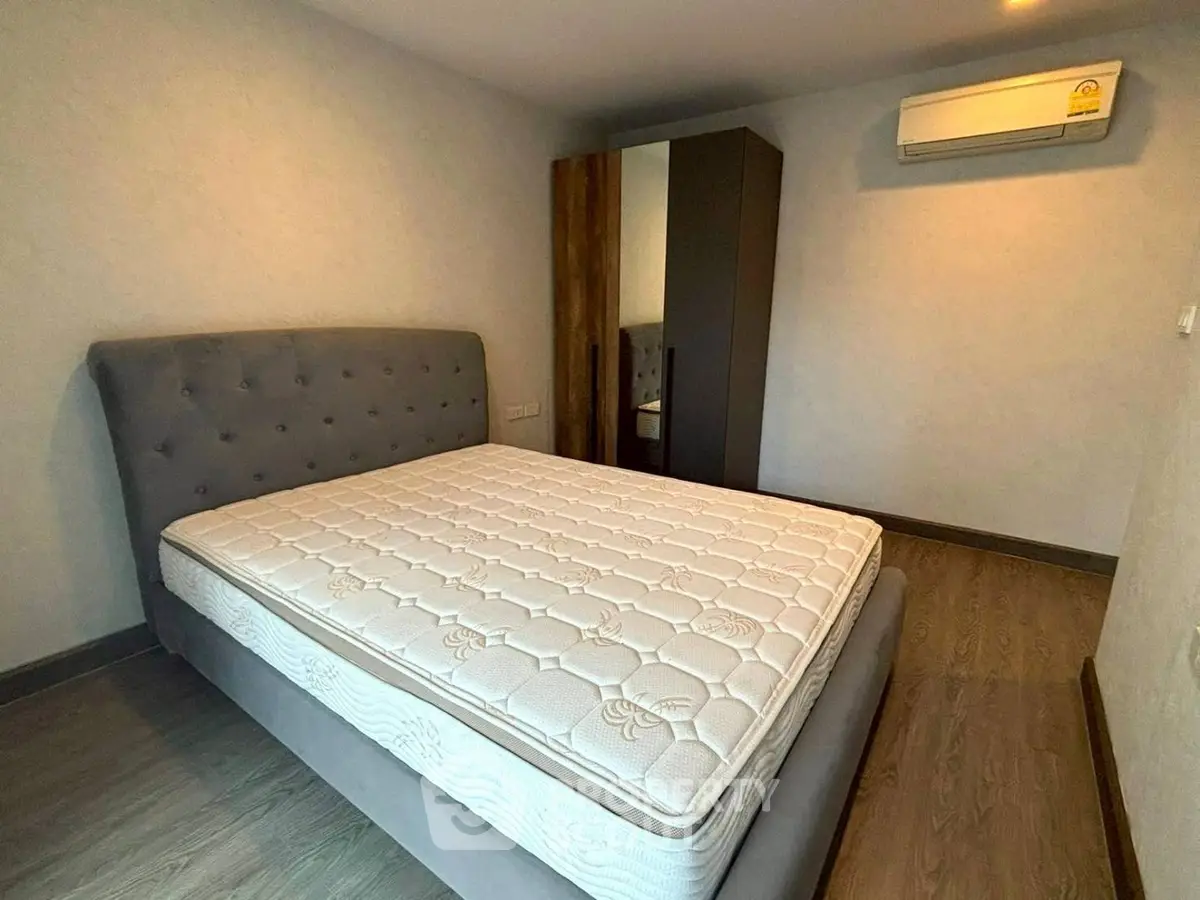Spacious bedroom with modern design and air conditioning, featuring a comfortable bed and sleek wardrobe.