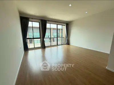 Spacious empty living room with large windows and wooden flooring