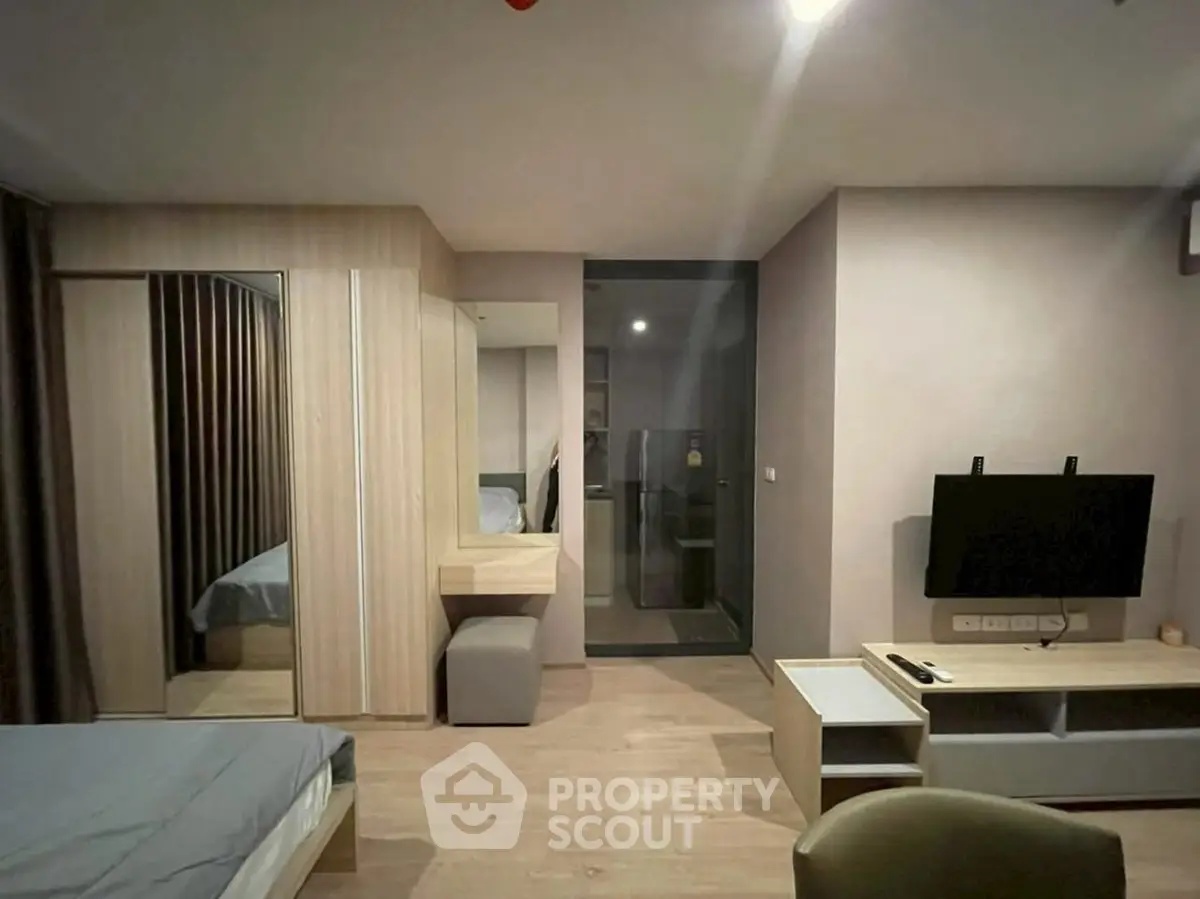 Modern bedroom with sleek design, featuring a wall-mounted TV and stylish furniture.
